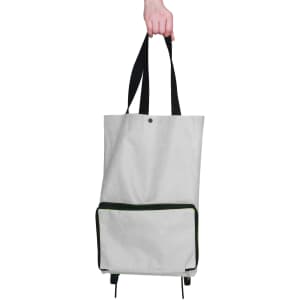 A grey collapsible shopping trolley bag with a green zippered pocket, held by a hand with black straps.