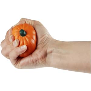 An orange pumpkin-shaped stress reliever being squeezed by a hand, featuring a smiling face design.