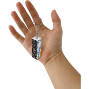 A custom square cube keyring held in a hand, featuring a multicolour design with geometric patterns.