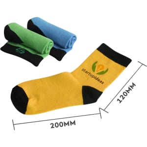 A pair of ankle socks in yellow with black accents, alongside two rolled pairs in green and blue. The socks feature a logo.