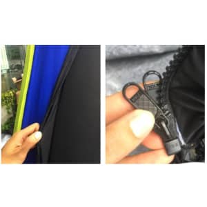 A close-up of a zipper on an inflatable marquee, featuring a black zipper with dual pulls and vibrant blue and green fabric.