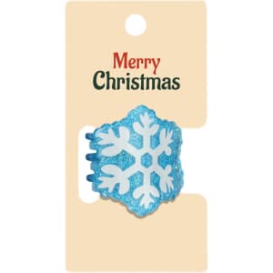 A blue snowflake hair claw featuring glitter, displayed on a festive card with a logo.