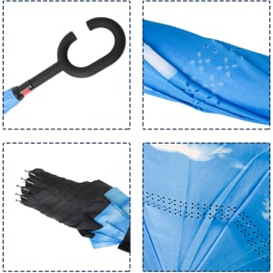 A reversible folding umbrella in blue, featuring a curved black handle and a patterned canopy with a variety of detailing.