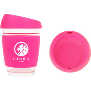 A reusable 12 OZ glass coffee cup in pink with a silicone sleeve and a matching lid, featuring a logo.