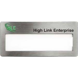 A silver metal name badge with a blank area for a name and a logo in one corner.