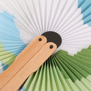 A wooden paper fan featuring a peach shape design with green and blue patterns. The fan has wooden handles.