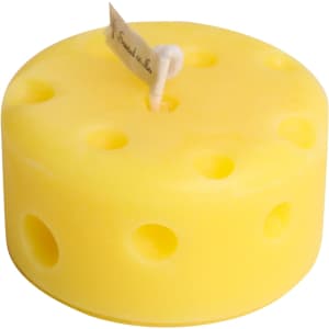 A round yellow candle designed to resemble cheese, featuring holes and a wick at the top.