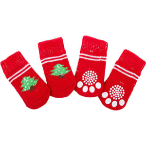 Four red pet socks displaying white paw prints and a green tree design. Each sock has a knitted texture and striped accents.