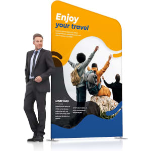 Inclined portable exhibit display wall in blue and orange, featuring a promotional travel design and a logo, with a person beside it.