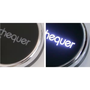 A black circular wireless charger with a metallic border, featuring a logo that lights up in white.