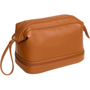 A large capacity PU toiletry bag in a rich brown colour with a zipped top and a wrist strap.