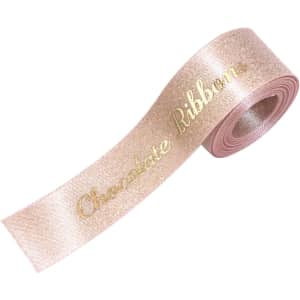 A roll of satin ribbon in a shimmering gold colour, featuring the text "Chocolate Ribbon" in gold lettering.