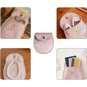 A pink oval velvet jewelry pouch with a snap closure, featuring various items like coins, headphones, and cards inside.