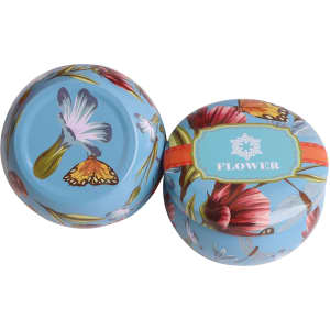 A set of four round tin candles featuring vibrant floral designs and a light blue background.