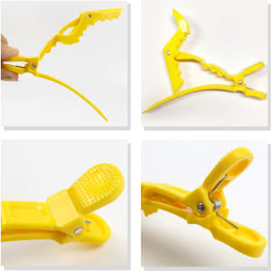 A yellow anti-slip positioning alligator clip with a textured grip and adjustable design, featuring a logo.