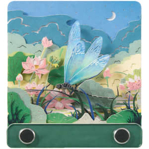 A 3D paper-cut sculpture notepad with a blue dragonfly design and a green base, featuring floral and landscape elements.