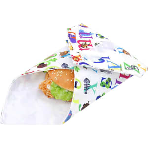 A reusable food wrap featuring a colourful design with letters and cartoon characters, tucked around a sandwich.