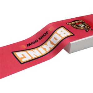 A red ribbon with graphics including the word "Boxing" and a logo, placed on a white surface.