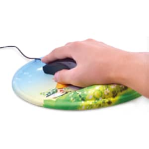 A round gel mouse mat featuring a colourful landscape design with a house and greenery, with a hand using a mouse on it.