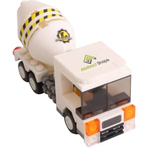 A white cement truck building block toy with yellow and black stripes, featuring a logo on the side.