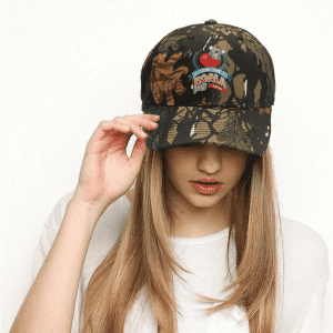 A camouflage cap featuring a mix of browns and greens, with a logo on the front.