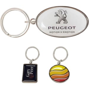 A collection of three keyrings, including a custom-shaped metal keyring with a logo, featuring silver and multicoloured designs.