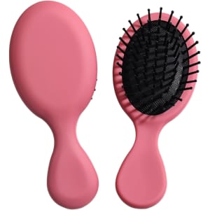 A pink mini paddle brush with a flexible base and black bristles, featuring a logo on the handle.