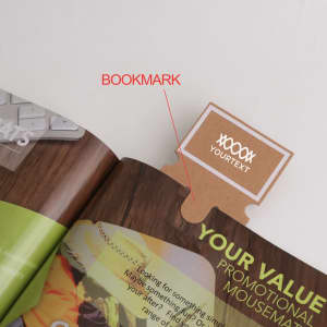 A brown bookmark with a tab, placed within the pages of a magazine or brochure, featuring a logo.