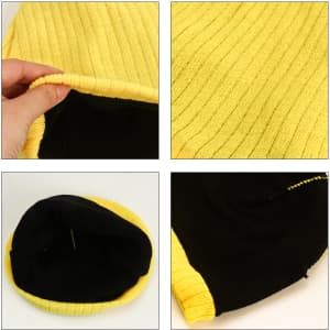 A yellow cable knit beanie featuring a textured ribbed design and a black interior with visible stitching.