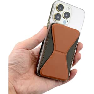 A hand holding a smartphone with a brown and grey PU MagSafe phone stand card holder attached to the back.