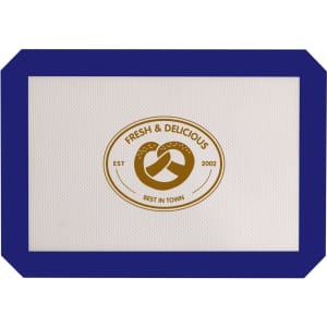A silicone baking mat in white with a blue border and a circular logo in the centre.