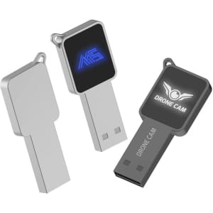 A silver and black square-shaped flash drive with a logo on one side and a smooth surface on the other.