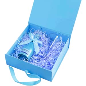 A light blue custom gift box containing a drink bottle and a glass, surrounded by blue shredded paper.