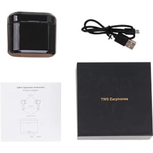 A black charging case with true wireless earbuds, a USB charging cable, and a user manual on a flat surface.