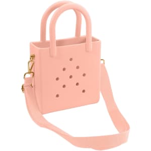 A mini beach bag in soft pink with holes, featuring two handles and a detachable shoulder strap.