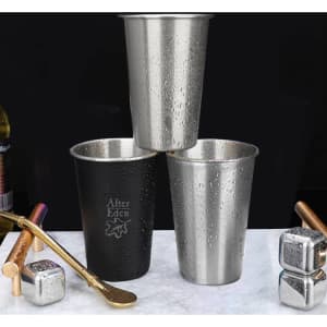 Three stainless steel cups in silver and black, featuring a logo, with condensation on their surfaces.