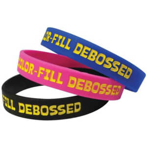Three debossed silicone wristbands in pink, blue, and black, featuring yellow text and branding.