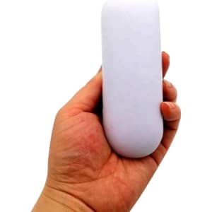 A hand holds a white, oval-shaped stress reliever. The item is smooth and has a minimalist design.