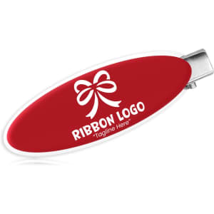 An oval acrylic hair clip in red with a silver clasp, featuring a logo on the surface.