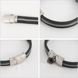 A sleek black bracelet featuring a silver buckle latch and intricate silver detailing. The bracelet has a polished finish.