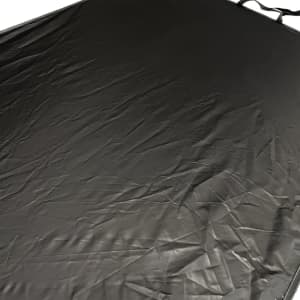 A light-blocking car sunshade in black with a textured surface, featuring straps for attachment.
