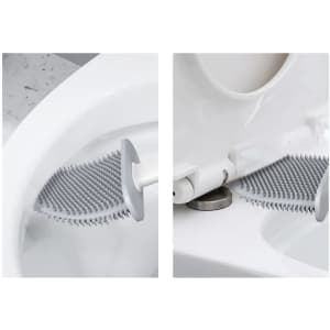 A silicone toilet brush in grey with a textured head, mounted against a white toilet bowl.
