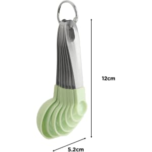 A set of measuring spoons in pastel green with a stainless steel ring for easy storage.