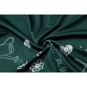 A close-up of dark green fabric featuring a pattern of white floral and gardening illustrations.