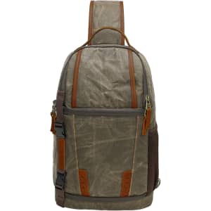 A waxed canvas camera sling bag in olive green with brown leather accents and a padded shoulder strap.