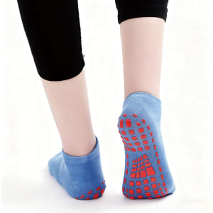 Low cut kids' socks in blue with red gripper soles, featuring a textured bottom for enhanced grip.