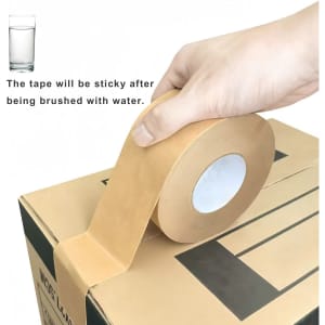 A hand holds a roll of brown water-activated gummed kraft paper tape above a cardboard box. The tape has a circular inner core.