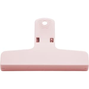 A pink plastic magnetic clip with a flat base and a hanging hole at the top. It features a logo on the surface.