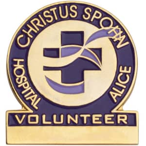 A gold and blue enamel lapel pin with a cross design and the word "VOLUNTEER" at the base.