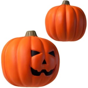An orange pumpkin stress reliever with a smiling face and raised ridges, featuring a brown stem.